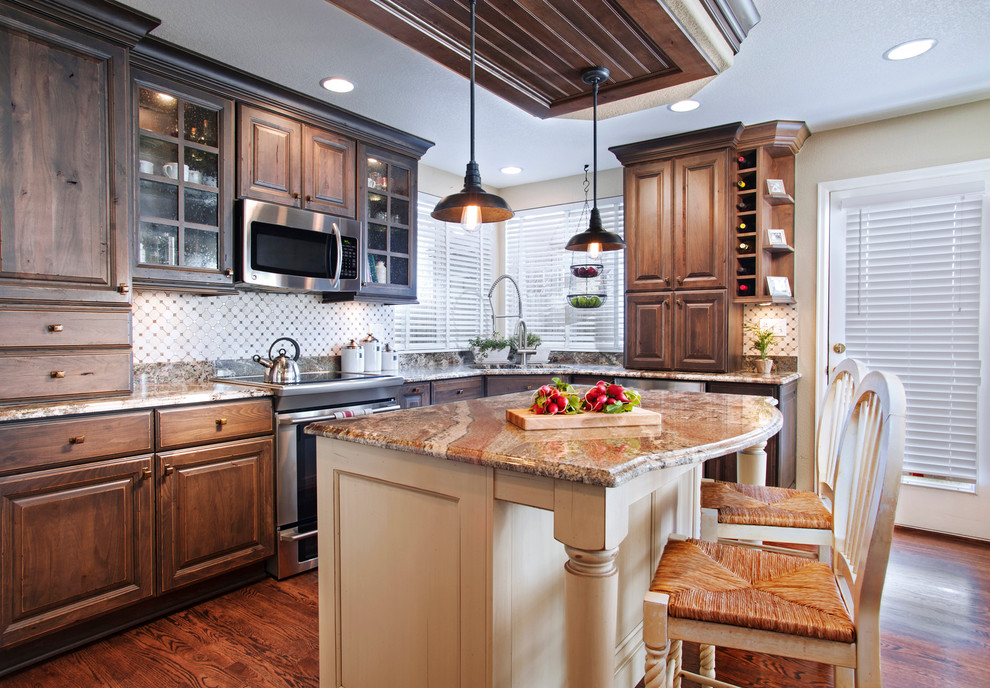 This is an example of a mid-sized traditional l-shaped eat-in kitchen in Denver with an undermount sink, raised-panel cabinets, dark wood cabinets, granite benchtops, white splashback, dark hardwood floors, with island, brown floor and multi-coloured benchtop.