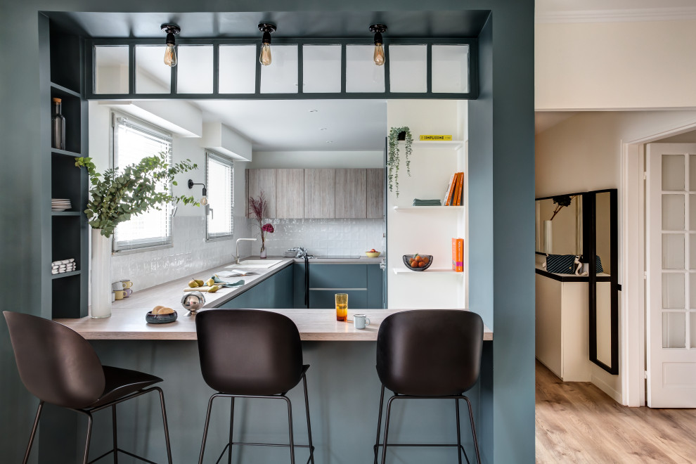 This is an example of a mid-sized contemporary u-shaped eat-in kitchen in Paris with laminate benchtops.