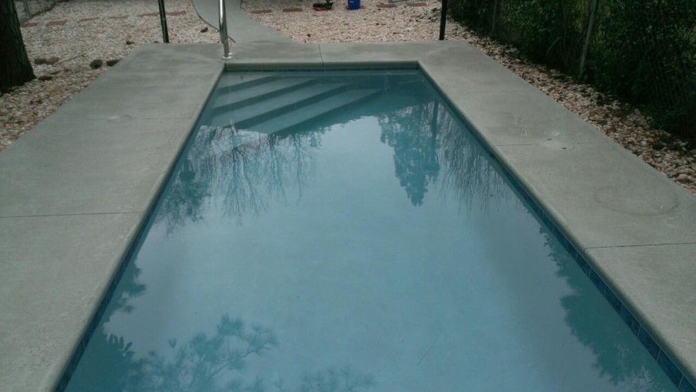 Small backyard rectangular pool in Jacksonville with concrete slab.