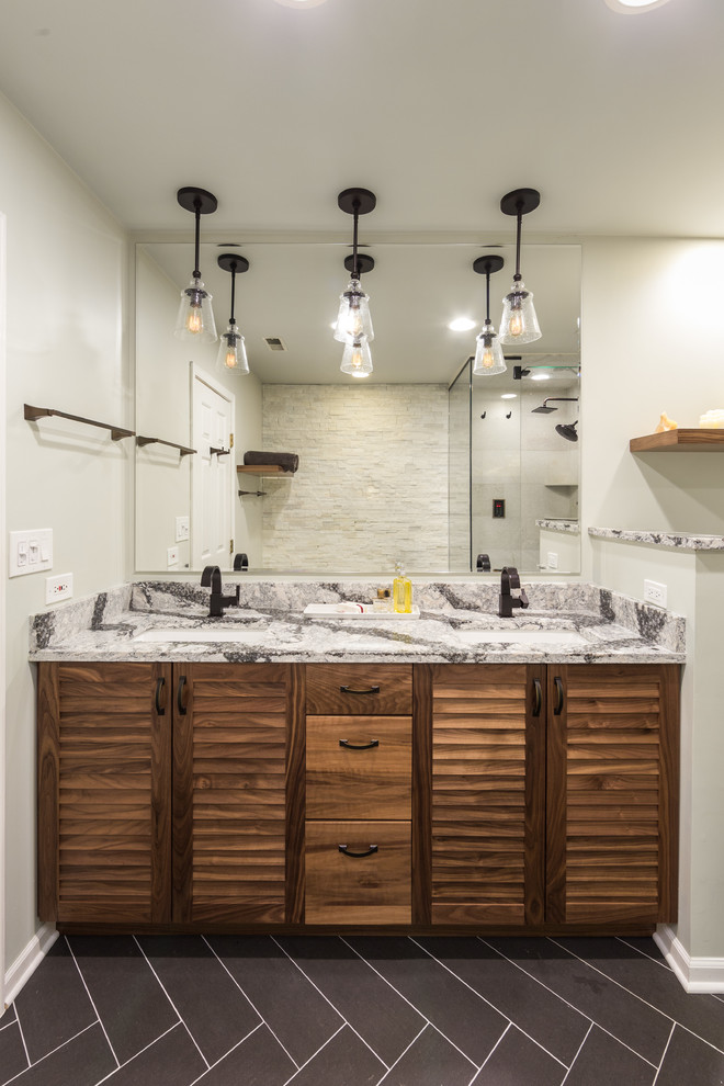 Inspiration for a mid-sized contemporary master bathroom in Chicago with flat-panel cabinets, medium wood cabinets, a drop-in tub, an alcove shower, a one-piece toilet, beige walls, cement tiles, an undermount sink, limestone benchtops, beige tile and travertine.