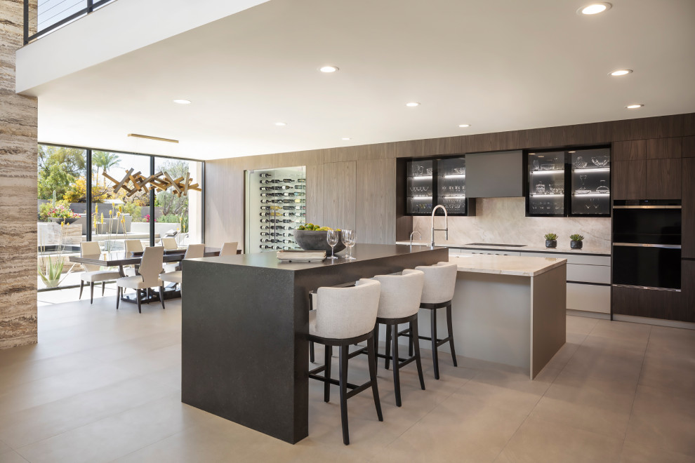 Expansive modern open plan kitchen in Phoenix with an undermount sink, glass-front cabinets, quartzite benchtops, beige splashback, engineered quartz splashback, porcelain floors, with island, beige floor and beige benchtop.