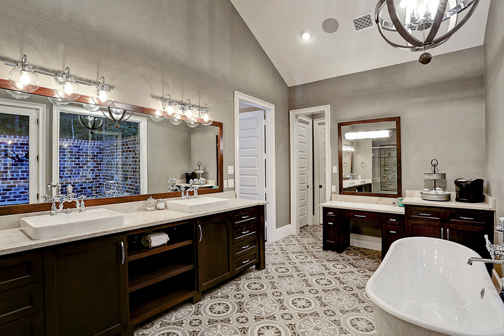 Design ideas for a large country master bathroom in Houston with furniture-like cabinets, brown cabinets, a freestanding tub, a double shower, beige tile, beige walls, ceramic floors, a drop-in sink, marble benchtops, beige floor and a hinged shower door.