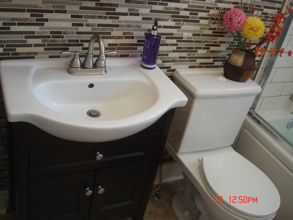 Example of a small minimalist beige tile and mosaic tile vinyl floor bathroom design in Toronto with an integrated sink, shaker cabinets, dark wood cabinets, solid surface countertops, a two-piece toilet and white walls