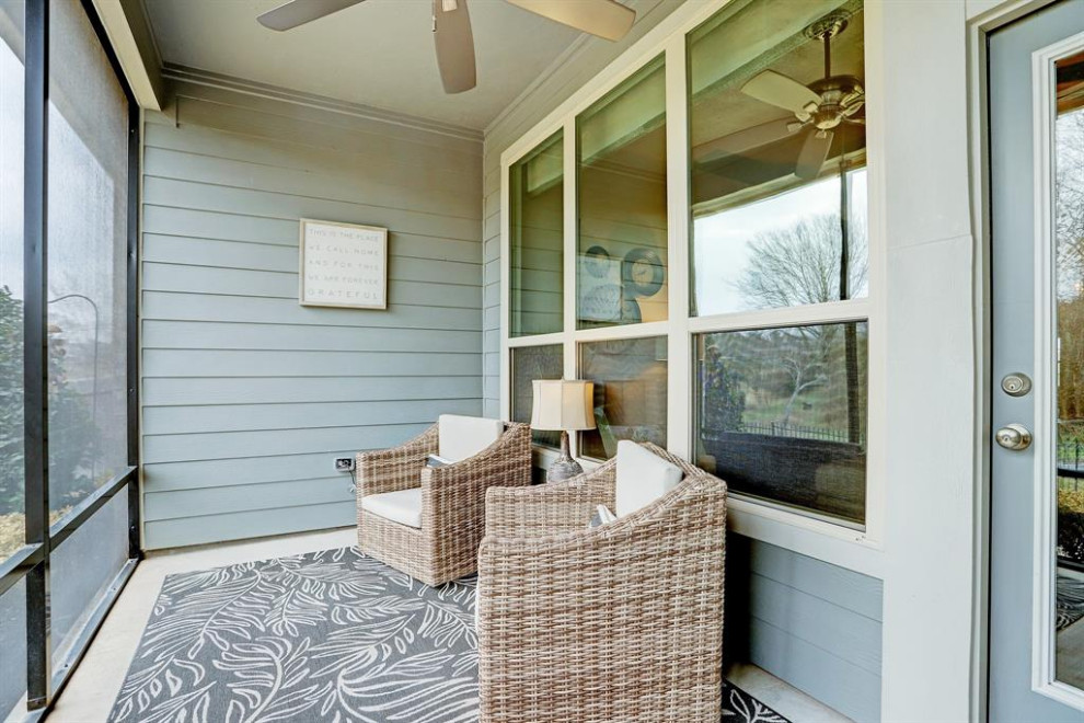 Inspiration for a small transitional backyard screened-in verandah in Houston with concrete slab, a roof extension and metal railing.