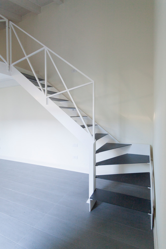 Photo of a small contemporary metal l-shaped staircase in Bologna with open risers and metal railing.