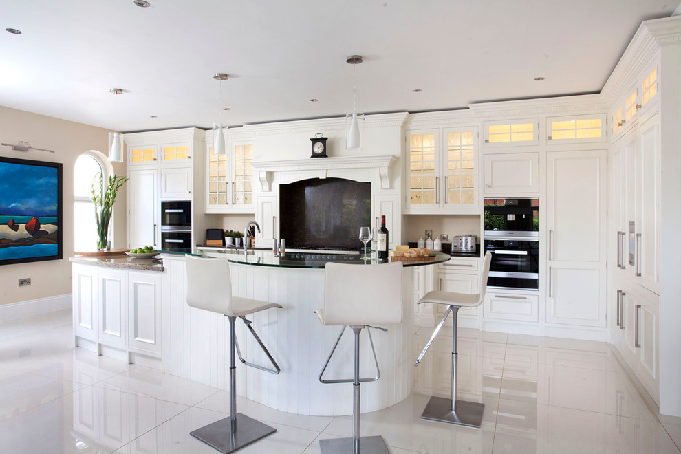 Photo of a large classic l-shaped kitchen/diner with a submerged sink, beaded cabinets, white cabinets, granite worktops, brown splashback, stone slab splashback, black appliances, porcelain flooring and an island.