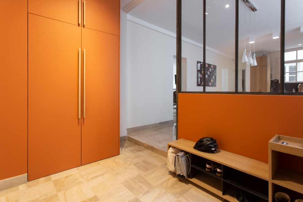 Inspiration for a mid-sized contemporary foyer in Paris with orange walls, travertine floors and beige floor.