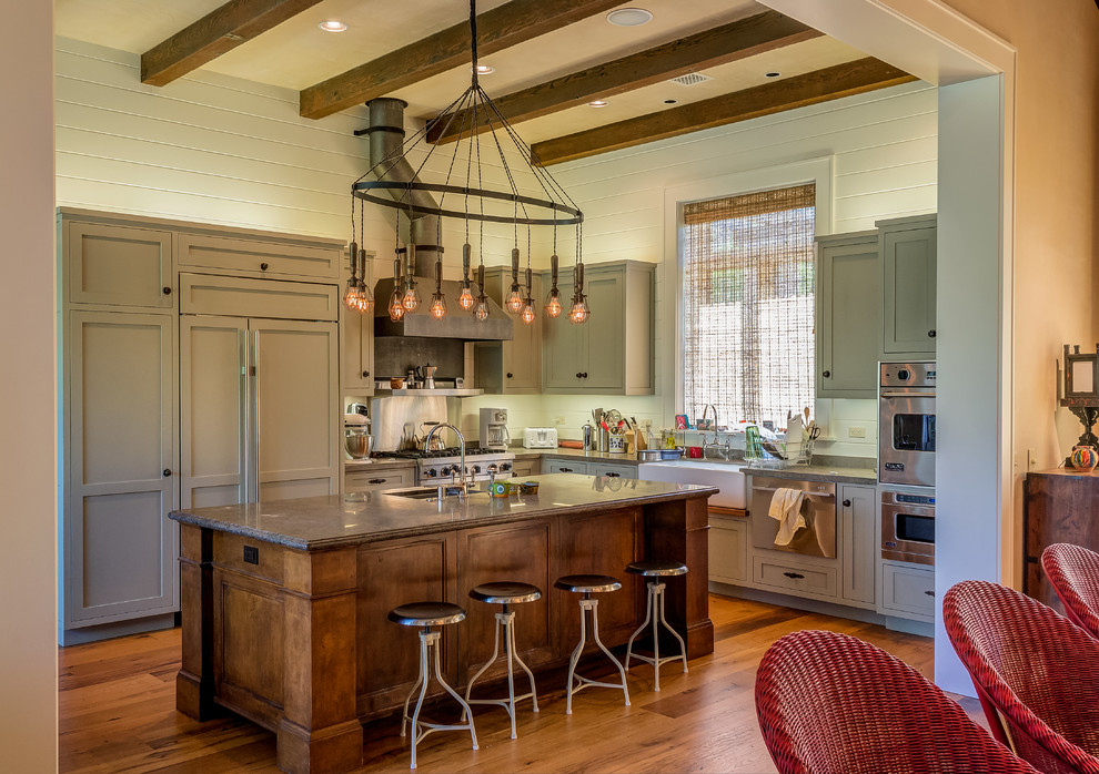 Eat-in kitchen - rustic l-shaped eat-in kitchen idea in Los Angeles with a farmhouse sink, shaker cabinets, green cabinets and paneled appliances