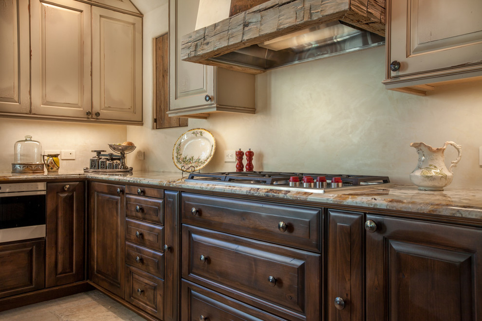 This is an example of a mid-sized traditional l-shaped open plan kitchen in Denver with raised-panel cabinets, panelled appliances, with island, a farmhouse sink, dark wood cabinets, granite benchtops and ceramic floors.