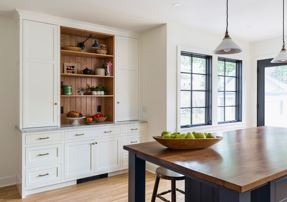 Inspiration for a mid-sized country l-shaped separate kitchen in Minneapolis with an undermount sink, recessed-panel cabinets, blue cabinets, wood benchtops, white splashback, marble splashback, stainless steel appliances, medium hardwood floors, with island, white floor and brown benchtop.