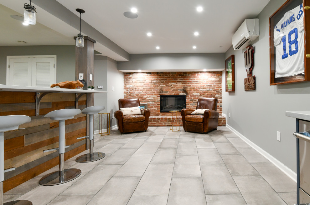 Example of a large transitional porcelain tile and gray floor basement design in DC Metro with a bar, gray walls, a standard fireplace and a brick fireplace