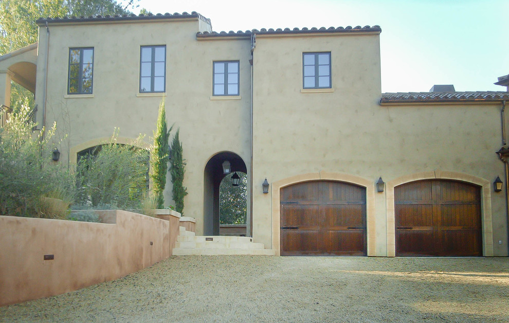 This is an example of a large mediterranean two-storey adobe beige exterior in San Francisco with a hip roof.