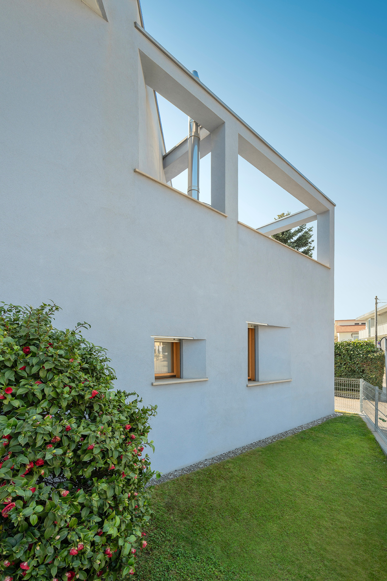 Immagine della villa grande bianca contemporanea a due piani con tetto piano, copertura in metallo o lamiera e rivestimento in cemento