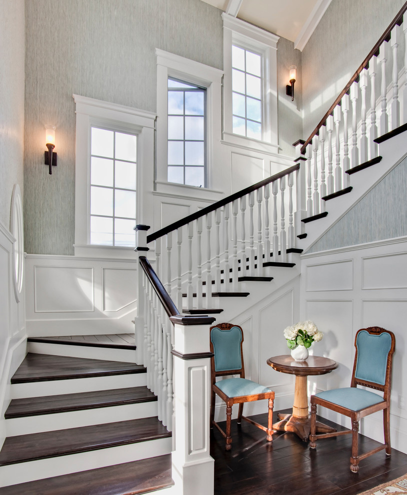 This is an example of a large traditional wood u-shaped staircase in San Diego with painted wood risers.