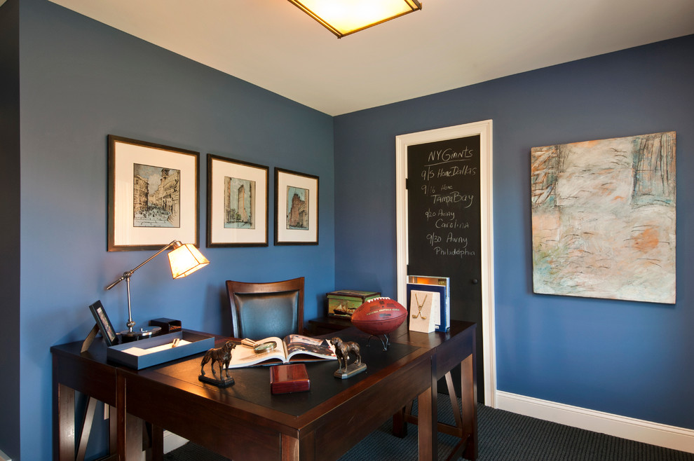 Photo of a mid-sized traditional study room in Boston with blue walls, carpet, no fireplace, a freestanding desk and black floor.