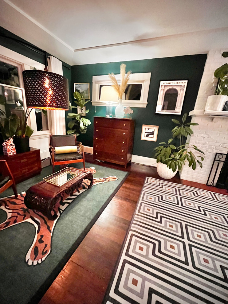 Design ideas for a medium sized eclectic open plan living room in Portland with green walls, dark hardwood flooring, a standard fireplace, a brick fireplace surround and a concealed tv.