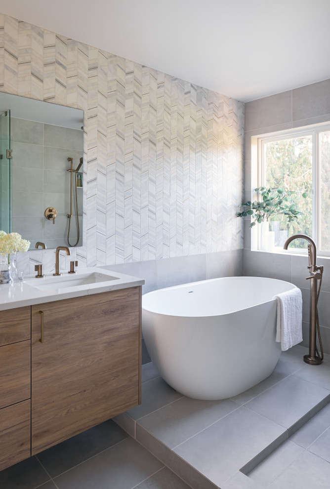 Freestanding bathtub - mid-sized transitional master white tile and marble tile porcelain tile, gray floor and double-sink freestanding bathtub idea in Seattle with flat-panel cabinets, light wood cabinets, a two-piece toilet, white walls, an undermount sink, quartz countertops, a hinged shower door, white countertops and a floating vanity