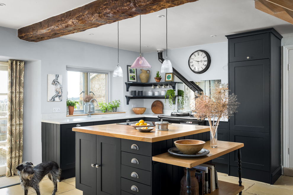 Design ideas for a mid-sized country l-shaped kitchen in Gloucestershire with black cabinets, with island, beige floor, white benchtop, a single-bowl sink and shaker cabinets.