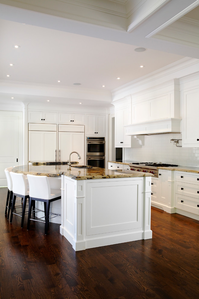 Photo of an expansive transitional l-shaped eat-in kitchen in Toronto with a double-bowl sink, white cabinets, dark hardwood floors and with island.
