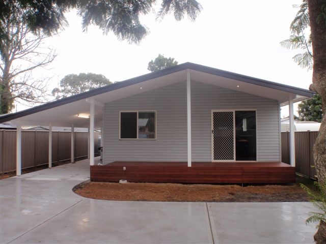 Photo of a small modern one-storey grey exterior in Central Coast with vinyl siding and a gable roof.