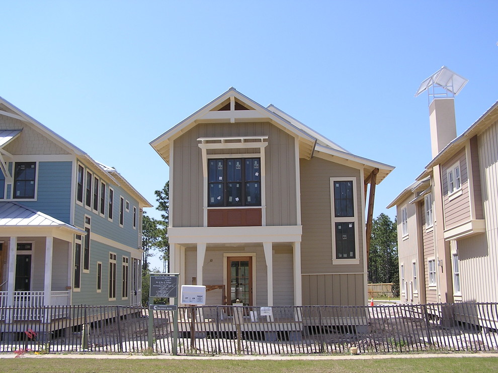 This is an example of a large beach style two-storey grey exterior in Miami with mixed siding and a gable roof.