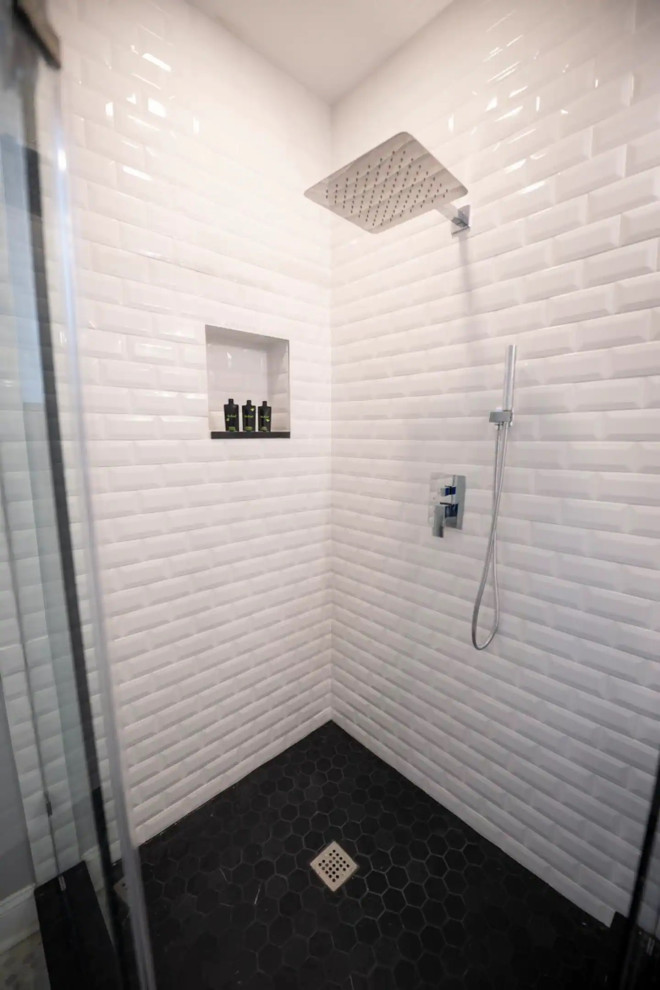 Small modern bathroom in DC Metro with flat-panel cabinets, medium wood cabinets, a corner shower, a one-piece toilet, white tiles, ceramic tiles, white walls, lino flooring, a console sink, white floors, a hinged door, a single sink and a built in vanity unit.