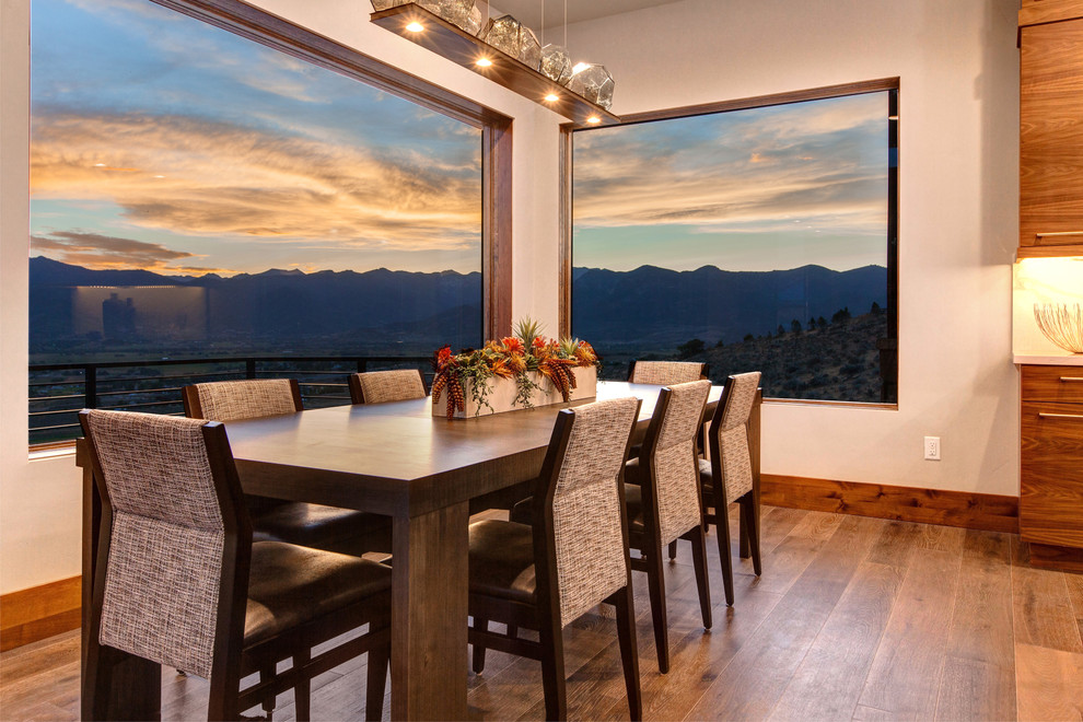 This is an example of a traditional open plan dining in Salt Lake City with white walls, medium hardwood floors and brown floor.
