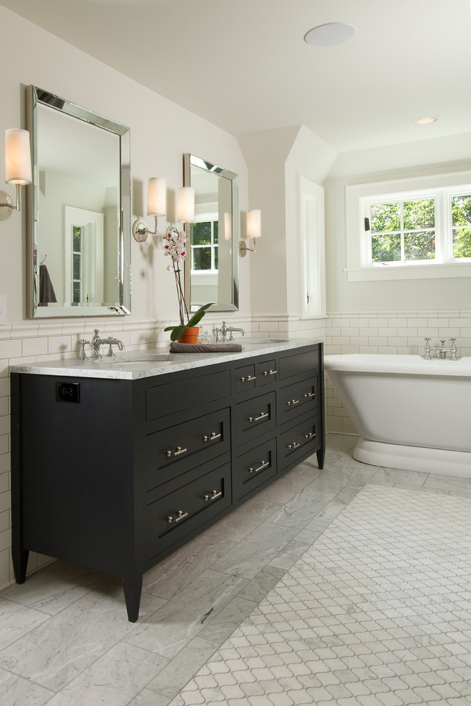 Inspiration for a master bathroom in Minneapolis with a freestanding tub, white tile, subway tile, marble floors, an undermount sink, marble benchtops and black cabinets.