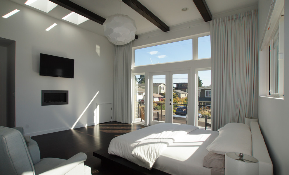 Design ideas for a large modern master bedroom in Seattle with white walls, dark hardwood floors, a ribbon fireplace and a plaster fireplace surround.