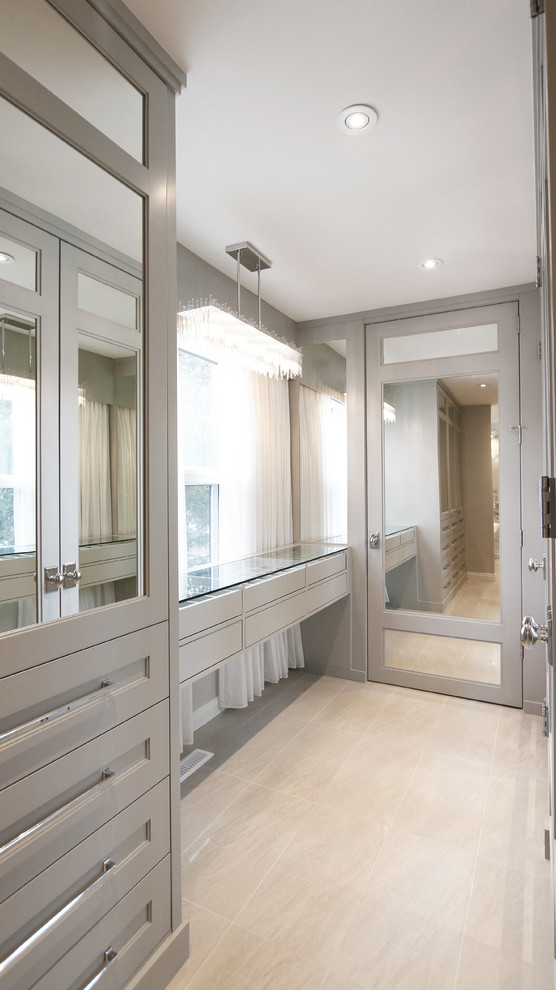 Large contemporary gender-neutral walk-in wardrobe in Calgary with beaded inset cabinets, grey cabinets, porcelain floors and beige floor.