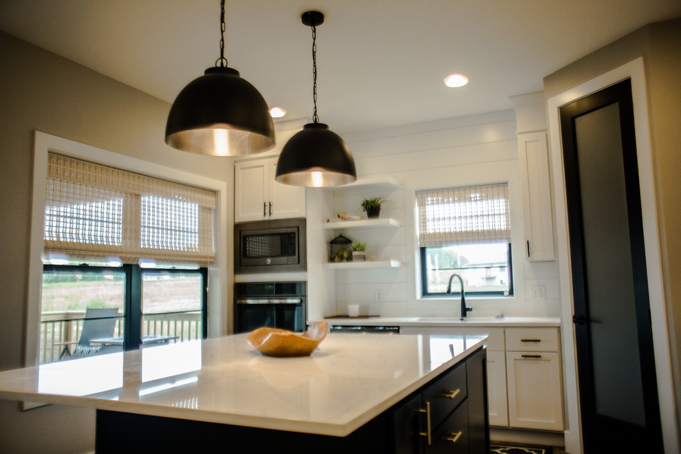 Small trendy kitchen photo in Cedar Rapids with an undermount sink, shaker cabinets, white cabinets, quartzite countertops, white backsplash, stainless steel appliances and an island