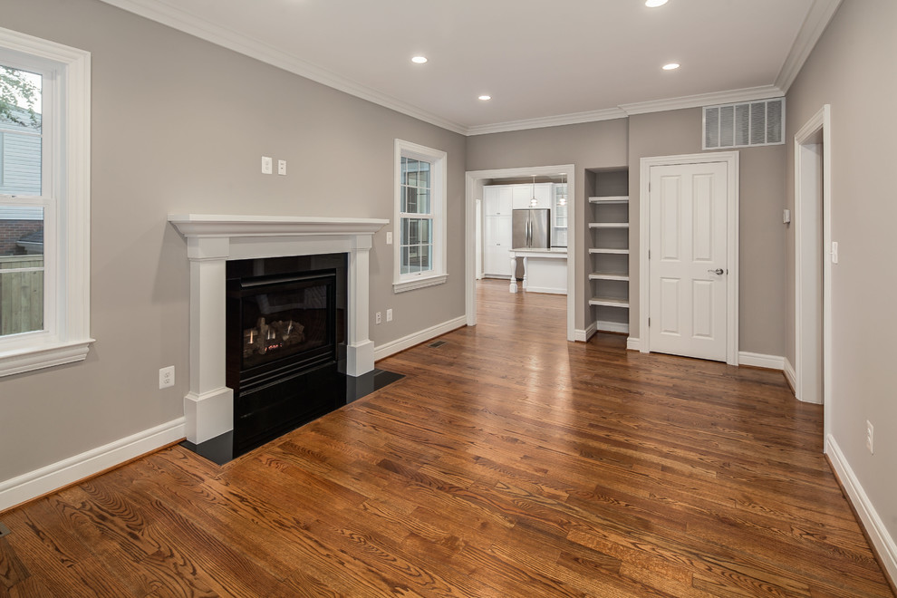 Inspiration for a large transitional formal enclosed living room in DC Metro with grey walls, medium hardwood floors, a standard fireplace, a plaster fireplace surround and no tv.