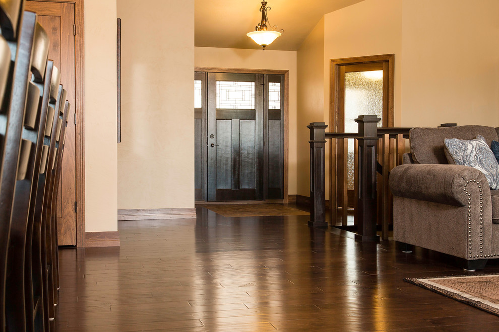Front door - mid-sized craftsman medium tone wood floor and brown floor front door idea with beige walls and a dark wood front door