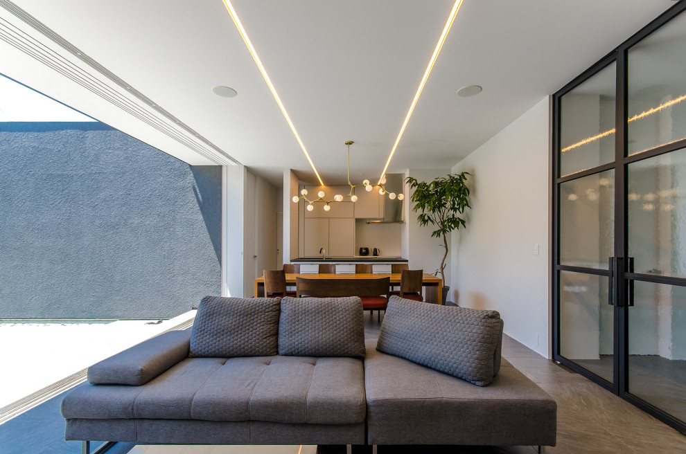 Ejemplo de salón abierto y blanco minimalista grande con paredes grises, suelo de baldosas de cerámica y suelo gris