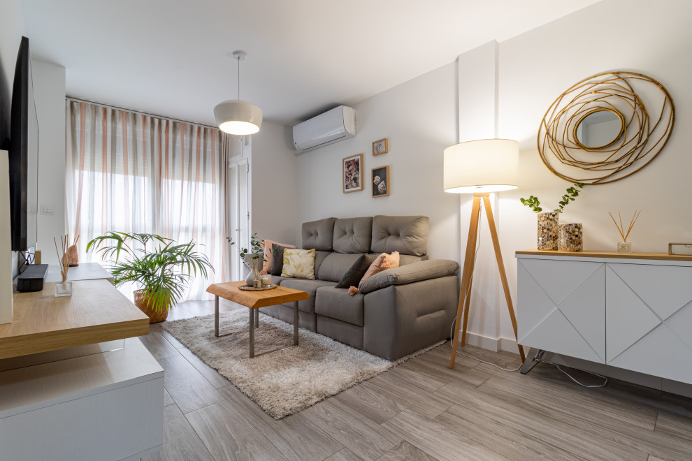 Idee per un piccolo soggiorno nordico aperto con pareti bianche, pavimento in gres porcellanato, TV a parete, pavimento grigio e tappeto
