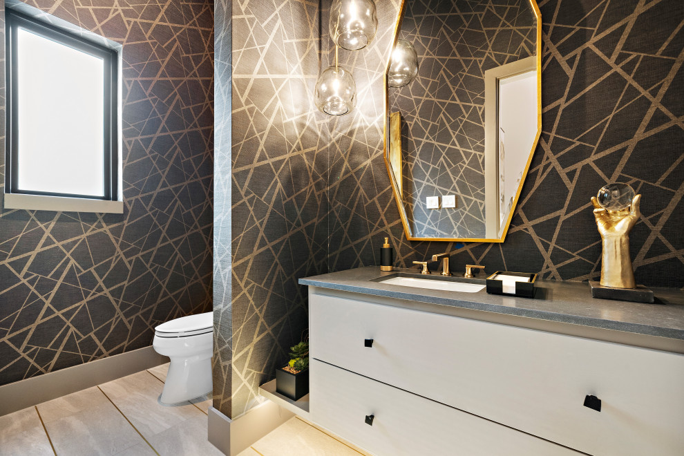 Inspiration for a mid-sized modern powder room in Houston with flat-panel cabinets, white cabinets, black walls, beige floor, grey benchtops, a floating vanity, wallpaper, ceramic floors and an undermount sink.