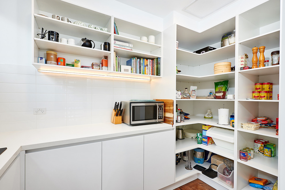 Small contemporary u-shaped kitchen pantry in Melbourne with open cabinets, white cabinets, quartz benchtops, white splashback, porcelain splashback, dark hardwood floors, no island and a single-bowl sink.