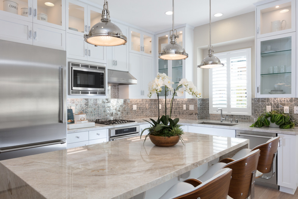Inspiration for a transitional l-shaped light wood floor open concept kitchen remodel in San Francisco with shaker cabinets, white cabinets, an island, an undermount sink, stainless steel appliances and metallic backsplash