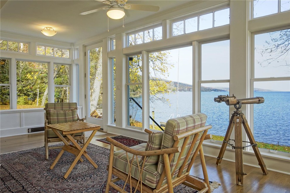 This is an example of a beach style sunroom in San Diego with medium hardwood floors, a standard ceiling and brown floor.