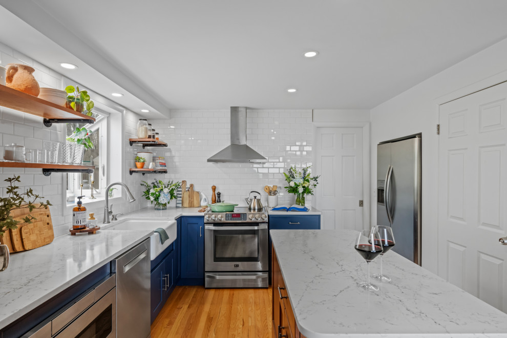 Exempel på ett klassiskt vit vitt l-kök, med en rustik diskho, skåp i shakerstil, blå skåp, vitt stänkskydd, stänkskydd i keramik, rostfria vitvaror, mellanmörkt trägolv och en köksö