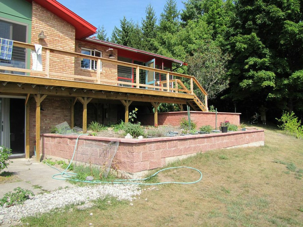 Inspiration for a mid-sized rustic full sun hillside concrete paver retaining wall landscape for summer.