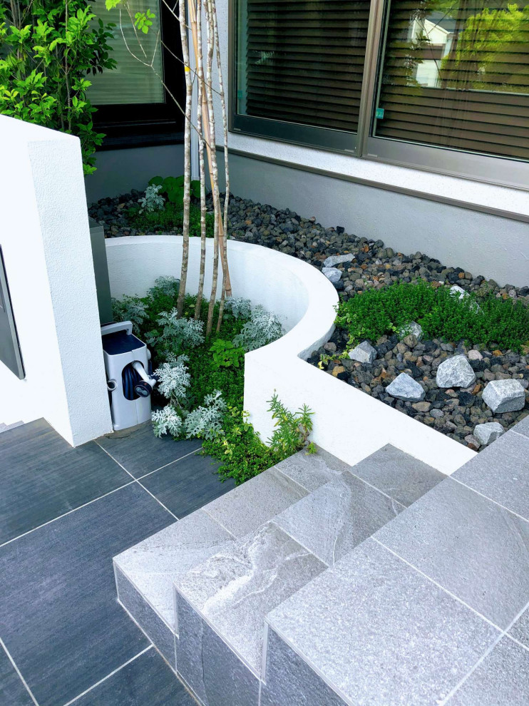 Modelo de terraza de estilo zen de tamaño medio en patio delantero con suelo de baldosas