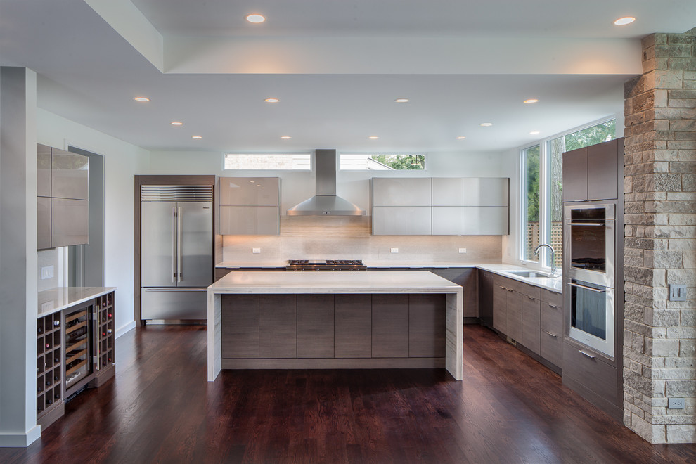Design ideas for a mid-sized contemporary u-shaped separate kitchen in Chicago with flat-panel cabinets, grey cabinets, limestone benchtops, with island, an undermount sink, beige splashback, limestone splashback, stainless steel appliances, dark hardwood floors and brown floor.