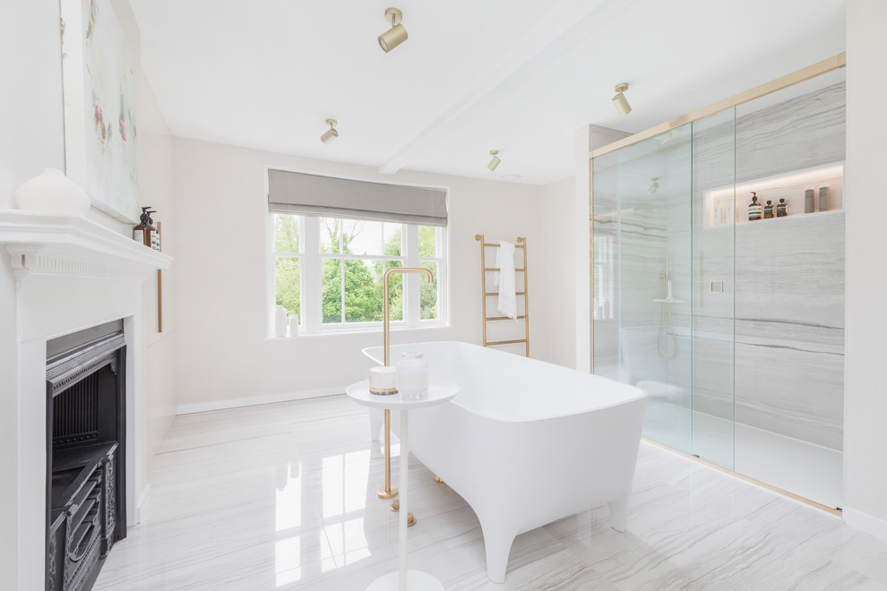 Photo of a large contemporary kids bathroom in Kent with beige cabinets, a freestanding tub, an open shower, a wall-mount toilet, white tile, marble, beige walls, marble floors, a wall-mount sink, marble benchtops, grey floor, a sliding shower screen and white benchtops.