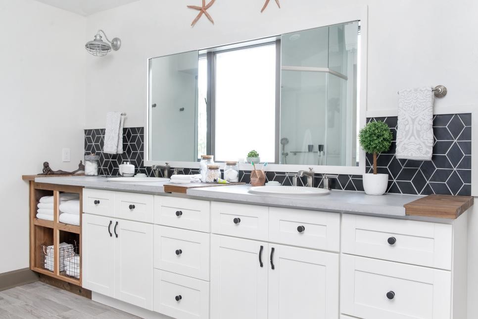 This is an example of a large beach style master bathroom in Orlando with shaker cabinets, white cabinets, an alcove shower, a one-piece toilet, black tile, ceramic tile, white walls, porcelain floors, a drop-in sink, concrete benchtops and grey floor.