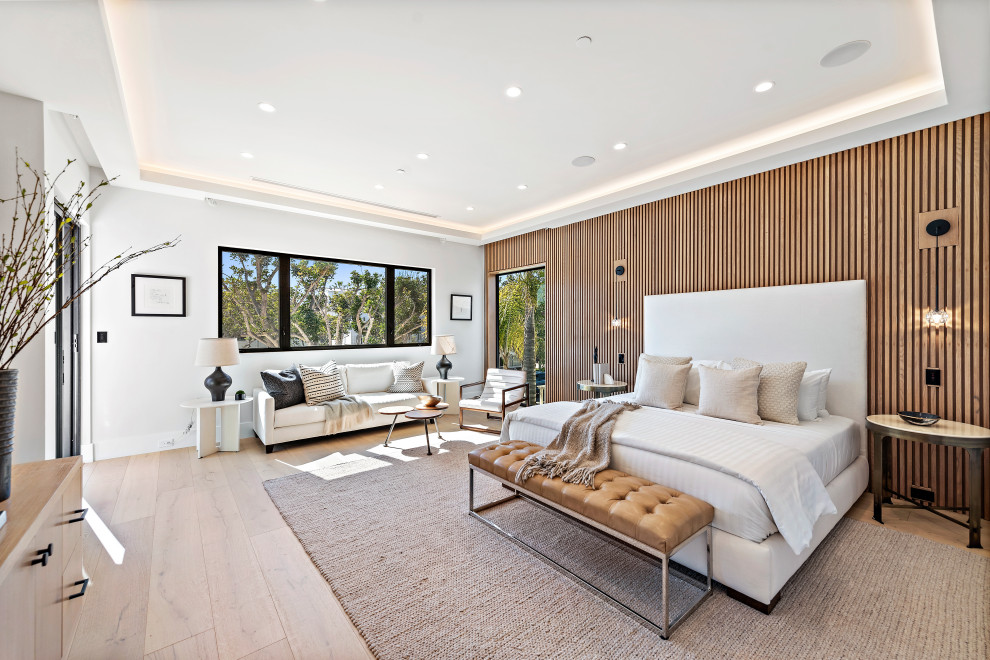 Modernes Hauptschlafzimmer mit weißer Wandfarbe, hellem Holzboden, beigem Boden und Holzwänden in Orange County