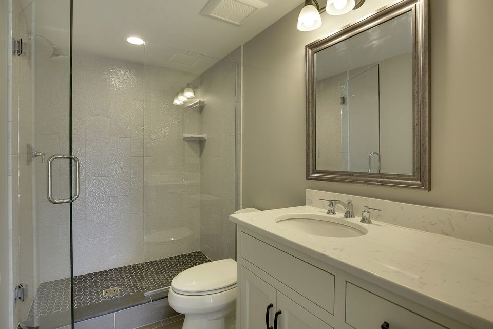 Inspiration for a mid-sized transitional 3/4 bathroom in Minneapolis with shaker cabinets, white cabinets, an alcove shower, white tile, grey walls, an undermount sink, porcelain tile, porcelain floors and quartzite benchtops.
