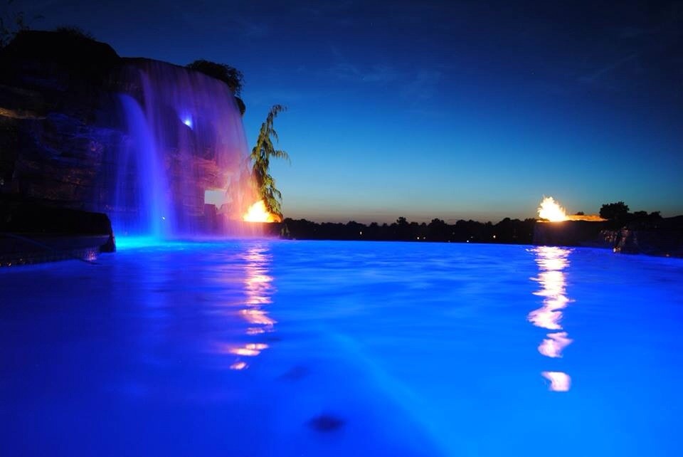 Example of a large mountain style backyard stamped concrete and custom-shaped natural pool fountain design
