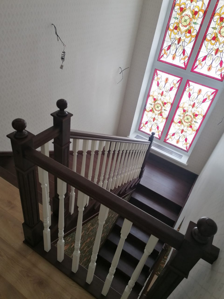 Idée de décoration pour un escalier tradition en U de taille moyenne avec des marches en bois, des contremarches en bois, un garde-corps en bois et du papier peint.