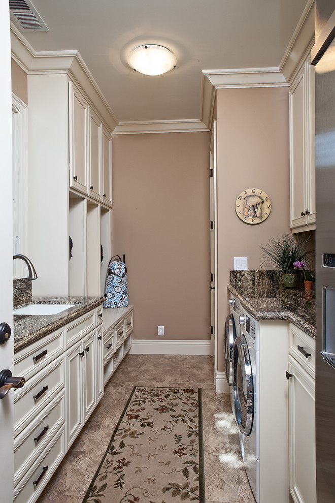 Photo of a mid-sized traditional galley utility room in San Francisco with an undermount sink, recessed-panel cabinets, white cabinets, beige walls, a side-by-side washer and dryer, granite benchtops, porcelain floors and beige floor.
